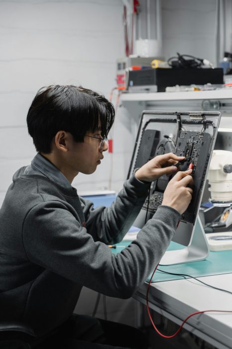 A skilled technician diagnosing and repairing computer hardware indoors.